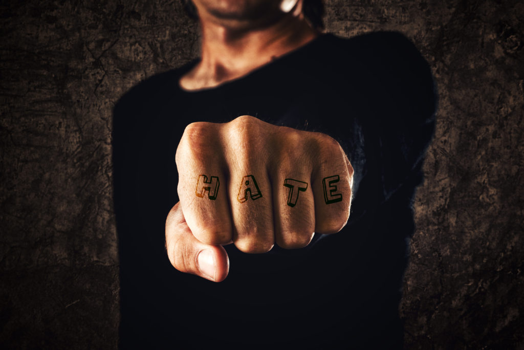 Hate. Hand with clenched fist on dark background. Power, determination, resistance concept.